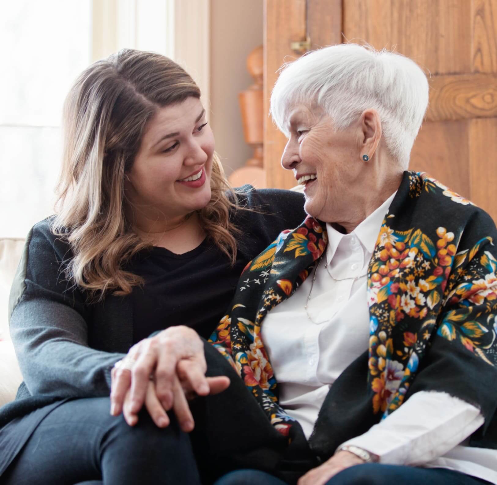 Wood-Glen-Court-Assisted-Living-team-member-sitting-with-and-supporting-a-senior-resident-in-Spring-Texas-highlighting-compassionate-assisted-living-fall-prevention,-safety-and-independence.