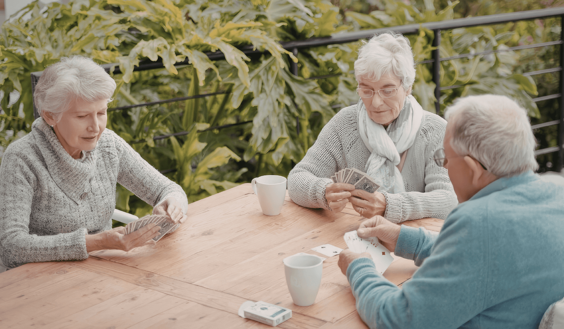 senior citizens playing cards outside.